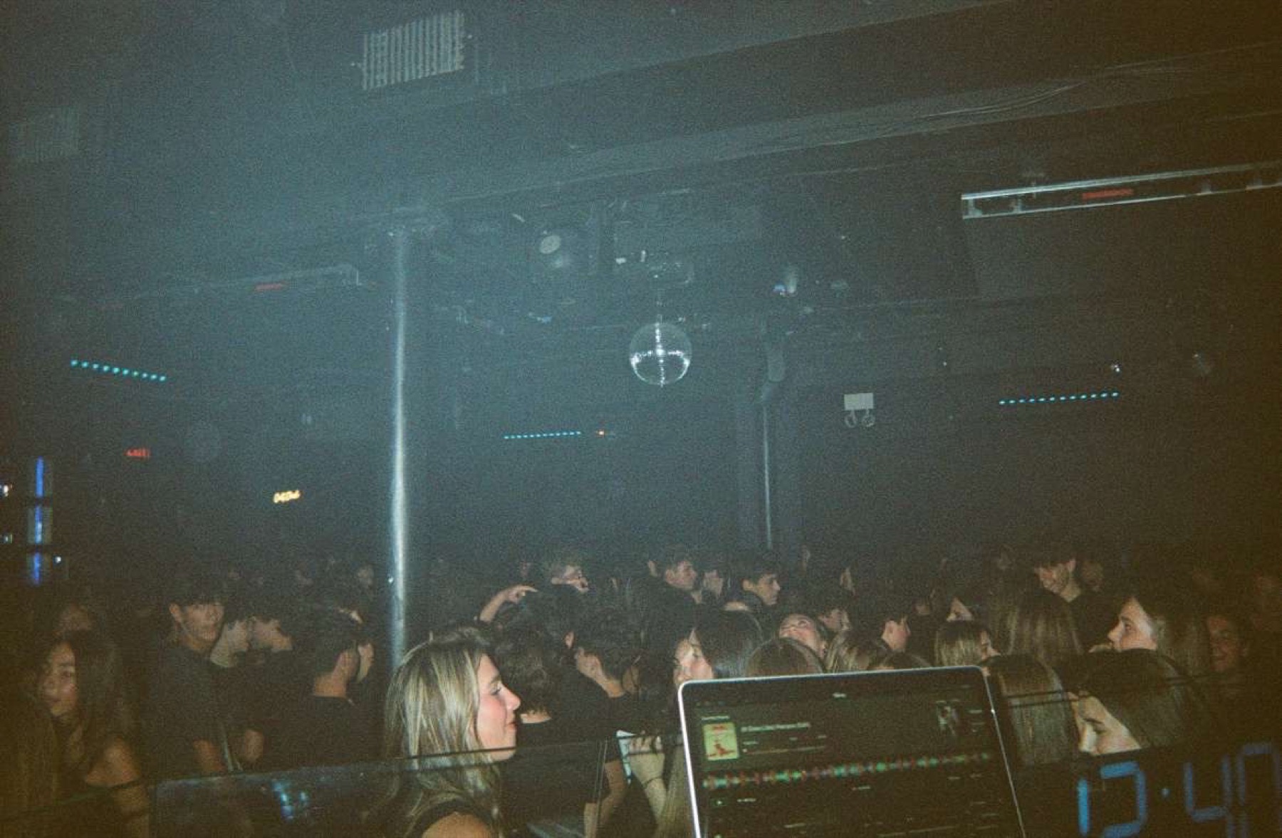 From the DJ booth at a CJL.Productions event — the floor fills beneath a disco ball and cool blue haze.